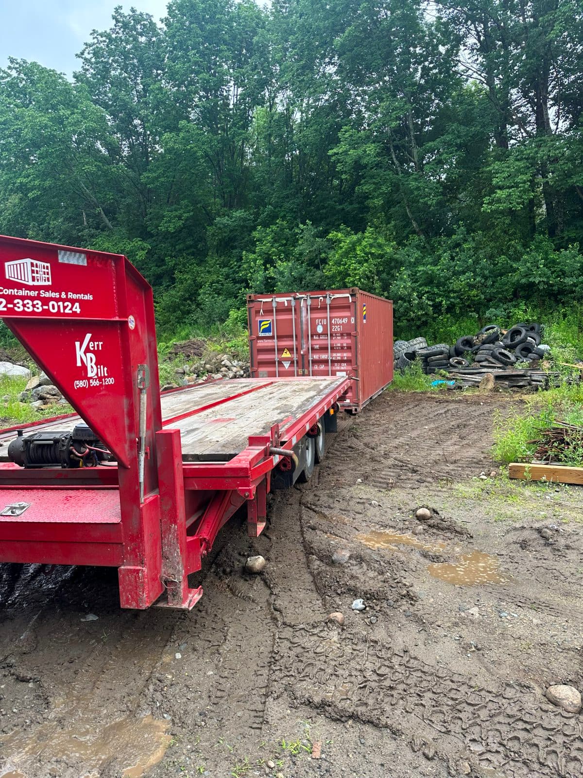 Trailer backed through deep mud to place a container