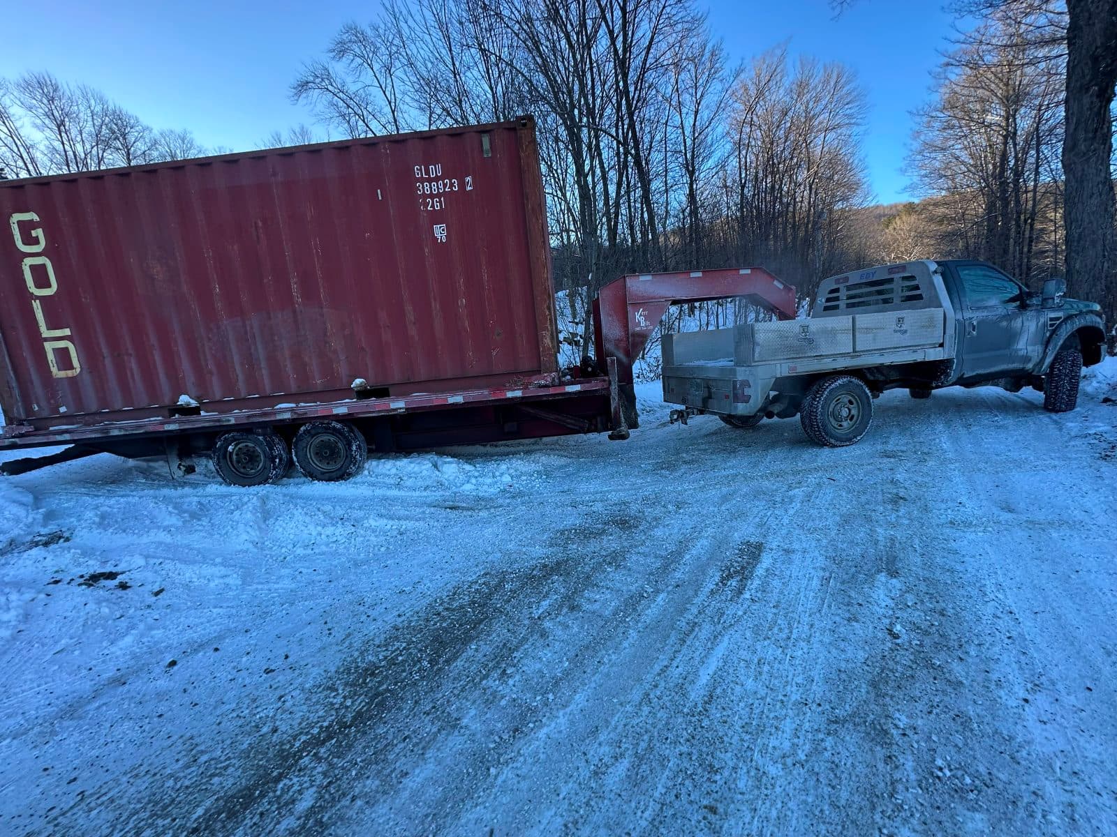 Container delivery on an icy dirt road at dusk